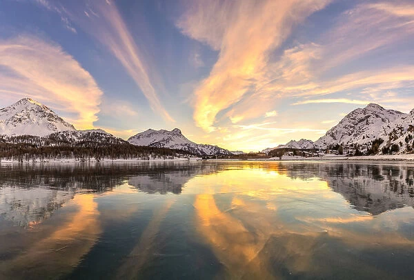 Colors of sunset reflected on the icy surface of Lake Sils, Engadine Valley, Graubunden