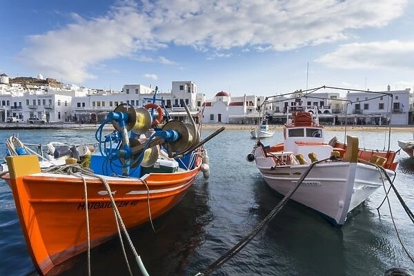 Colourful boats in harbour, whitewashed Mykonos Town (Chora) with windmills and churches