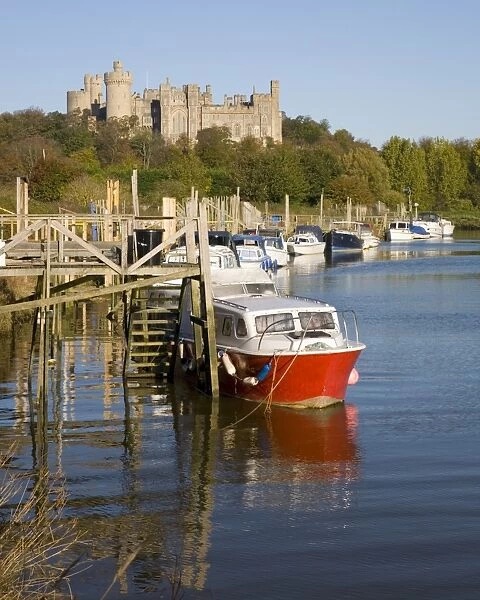 Colourful boats moored on the River Arun beneath the castle, Arundel, West Sussex
