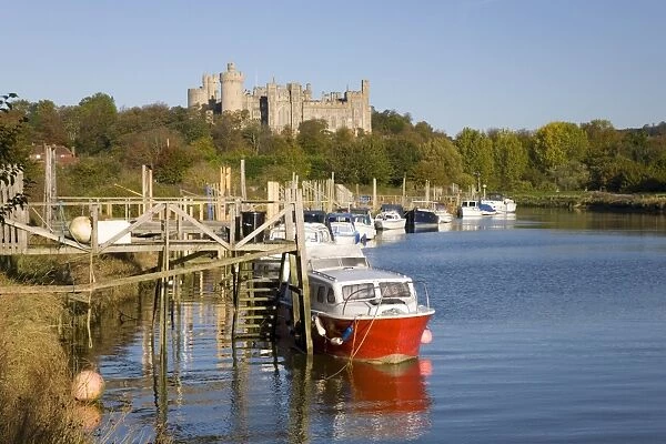Colourful boats moored on the River Arun beneath the castle, Arundel, West Sussex