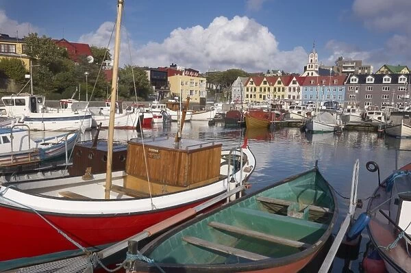 Colourful boats and picturesque gabled buildings along the quayside in Vestaravag harbour