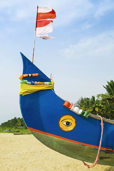 Colourful fishing boat with Indian flag and golden eye motifs on Marari Beach