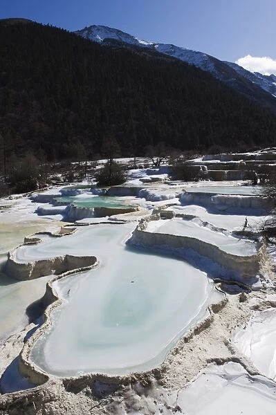 Colourful pools of calcite deposit frozen at Huanglong National Park, UNESCO World Heritage Site