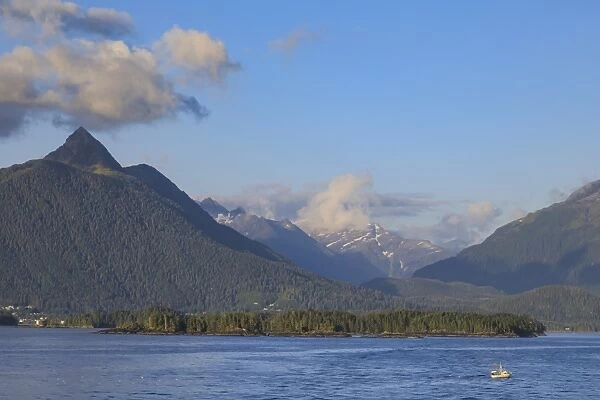 Commercial fishing vessel, forested snow-capped mountains, rare evening sun, Sitka Sound