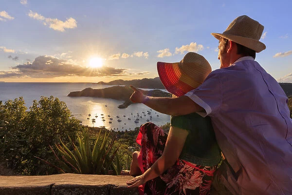 Couple look to the English Harbor from Shirley Heights at sunset, Antigua, Antigua and Barbuda