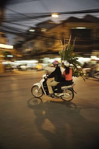 Couple on moped carrying floral display, Hanoi, Vietnam, Indochina, Southeast Asia, Asia