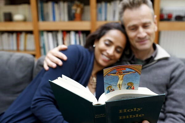 Couple reading the Bible at home, Paris, France, Europe