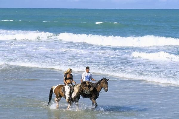 Couple riding horses on the beach, Tibau do Sul, Natal, Rio Grande do Norte state