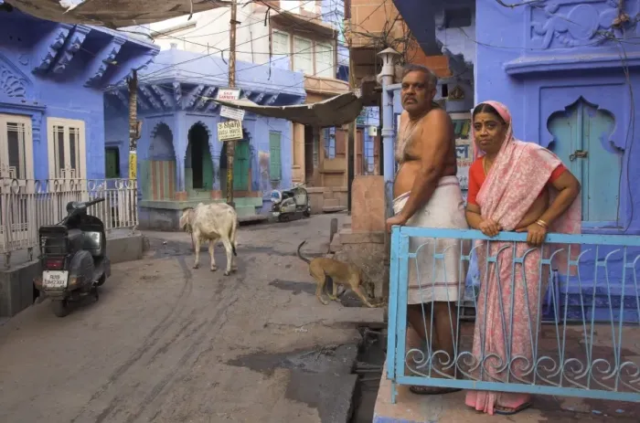 Framed Print : Couple standing outside blue painted residential haveli Framed Print : Couple standing outside blue painted residential haveli