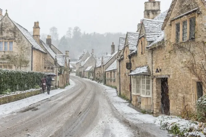 Framed Print : A couple walking up the hill in Castle Combe with an umbrella protecting them Framed Print : A couple walking up the hill in Castle Combe with an umbrella protecting them