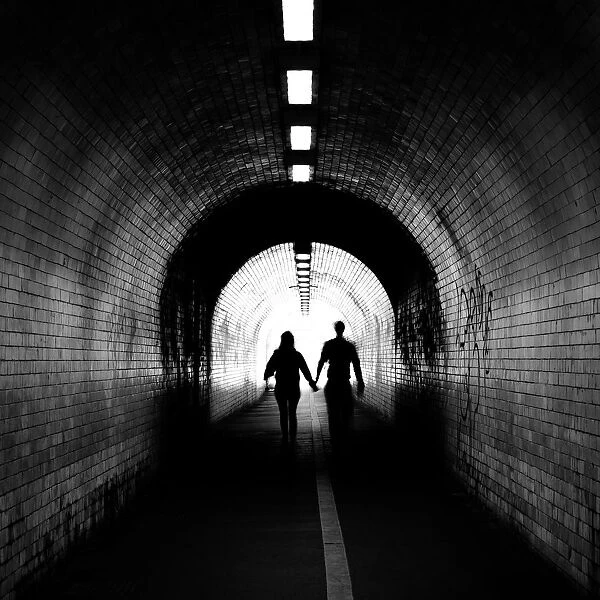 Couple walking into the light, York tunnel, York, England, United Kingdom, Europe