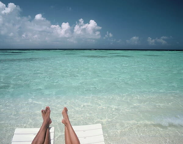 Couples legs on a beach, Maldives, Indian Ocean, Asia