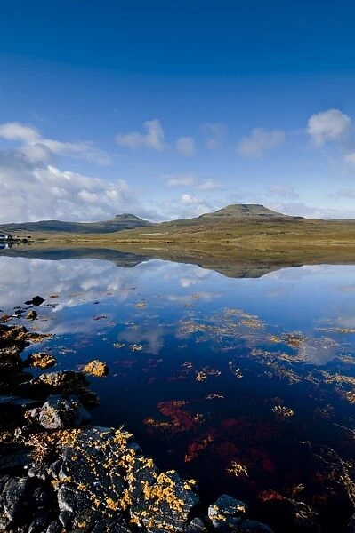 Craggy seascape of Loch Dunvegan on the Isle of Skye, with Macleods Table in background. Isle of Skye, Inner Hebrides, Scotland, United Kingdom, Europe