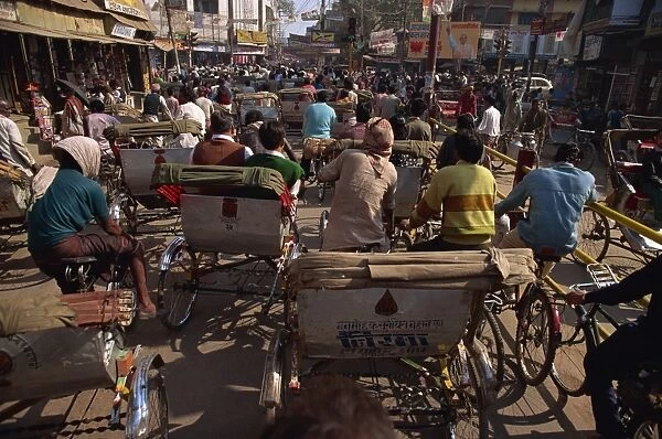 Crowded street scene with rickshaws and bicycles