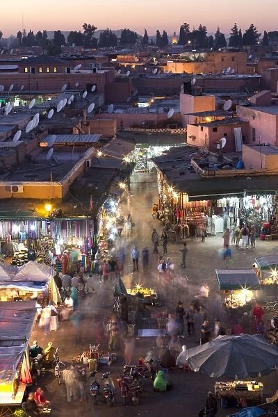 Crowds of locals and tourists walking among the shops and stalls in the Djemaa el Fna at sunset, Marrakech, Morocco, North Africa, Africa
