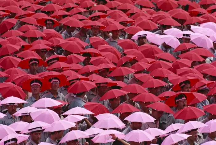 Framed Print : Crowds wearing red and pink umbrella hats during Framed Print : Crowds wearing red and pink umbrella hats during