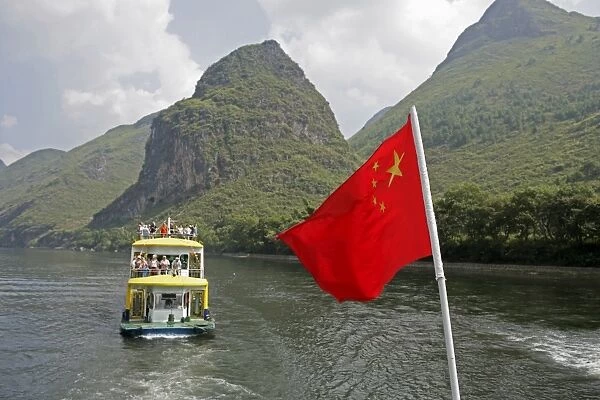 Cruise boat with Chinese flag on Li River between Guilin and Yangshuo, Guilin