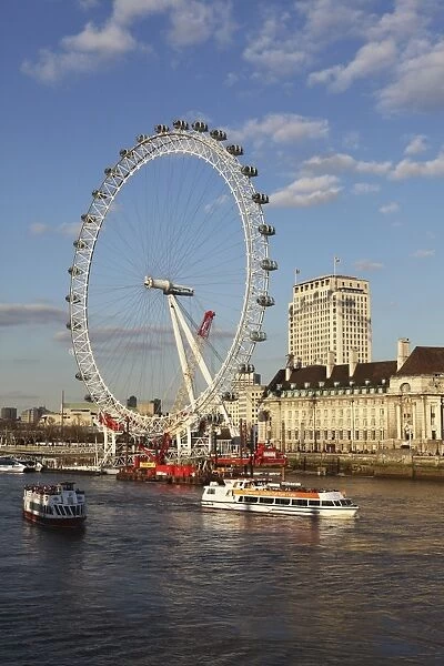 Cruise boats sail past County Hall and the London Eye on the South Bank of the River Thames, London, England, United Kingdom, Europe