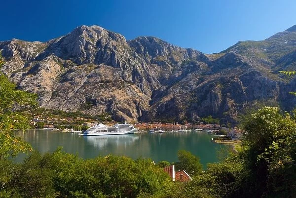 Cruise ship dwarfs the Old Town (Stari Grad), Kotor, Bay of Kotor, UNESCO World Heritage Site, Montenegro, Europe