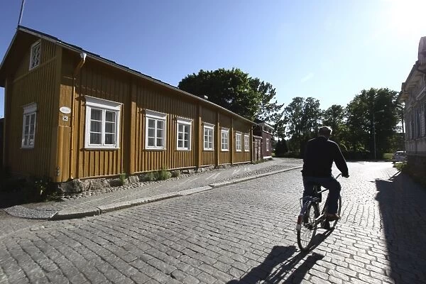 Cyclist on cobblestone street, Old Town, Rauma, Satakunta, Finland, Scandinavia, Europe