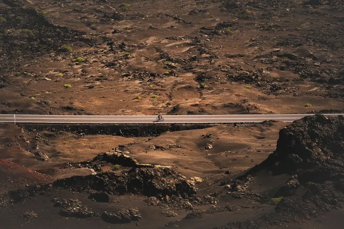 Framed Print : A cyclist cycling on a road in the Timanfaya national park in Lanzarote in the Canary Islands, Spain Framed Print : A cyclist cycling on a road in the Timanfaya national park in Lanzarote in the Canary Islands, Spain