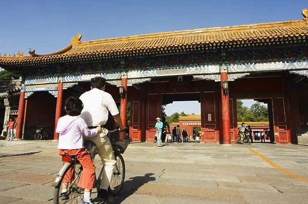 A cyclist at a gate to Zijin Cheng The Forbidden City Palace Museum, UNESCO World Heritage Site