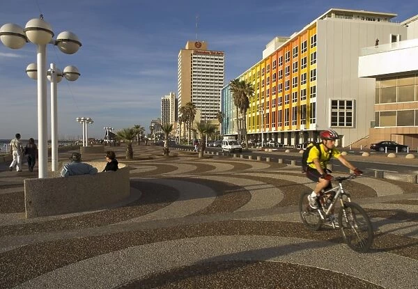 Cyclist on Jerusalem Beach Promenade with Dan hotel
