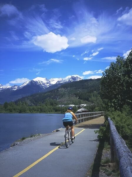 Cyclist on Valley Trail in summer beside Green Lake in the Whistler valley