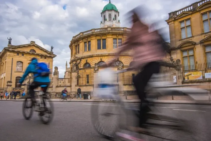 Framed Print : Cyclists passing the Sheldonian Theatre, Oxford, Oxfordshire, England, United Kingdom