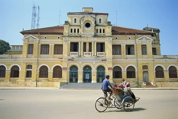 A cyclo passing the Old Post Office in Phnom Penh in Cambodia, Indochina