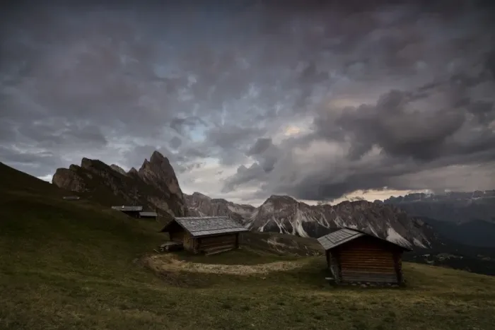 Framed Print : Dark clouds on green meadows and huts of the Odle mountain range seen from Seceda Framed Print : Dark clouds on green meadows and huts of the Odle mountain range seen from Seceda