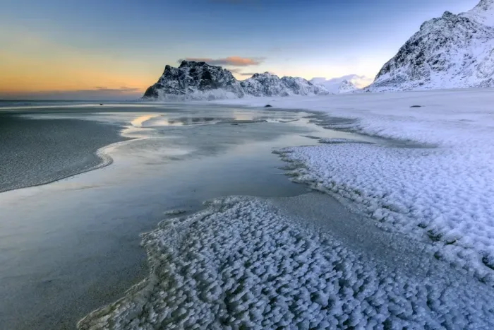 Framed Print : Dawn illuminates the beach covered with frozen snow in the cold sea of Uttakleiv Framed Print : Dawn illuminates the beach covered with frozen snow in the cold sea of Uttakleiv
