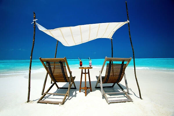 Two deck chairs under shelter on beach, Maldives, Indian Ocean, Asia