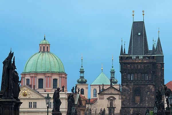Details of statues and spires at Charles Bridge, featuring dome of Church of Saint Francis of Assisi and Old Town Bridge Tower, UNESCO World Heritage Site, Prague, Bohemia, Czech Republic (Czechia), Europe