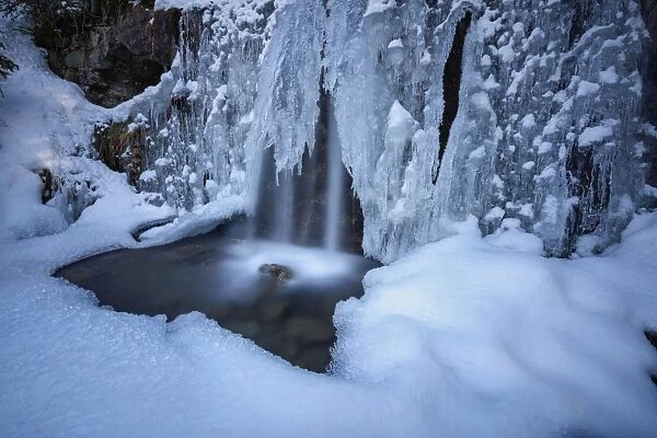 Details of a waterfall framed by ice and snow, Switzerland, Europe