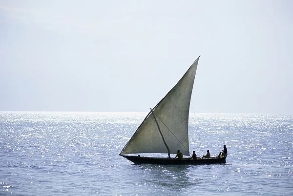 Dhow in silhouette on the Indian Ocean, off Stone Town, Zanzibar, Tanzania