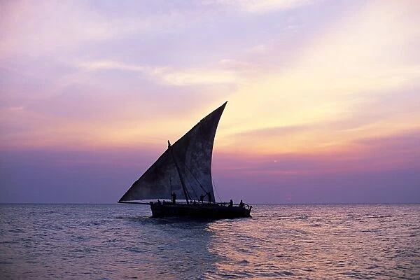 Dhow in silhouette on the Indian Ocean at sunset, off Stone Town, Zanzibar