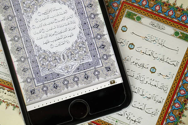 Digital Quran on a smartphone and Holy Quran book, Surat al-Fatiah, the first chapter