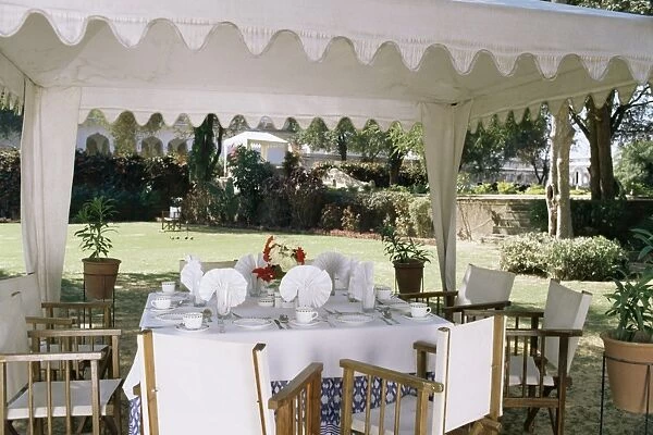 Dining under tented awnings in the garden with croquet