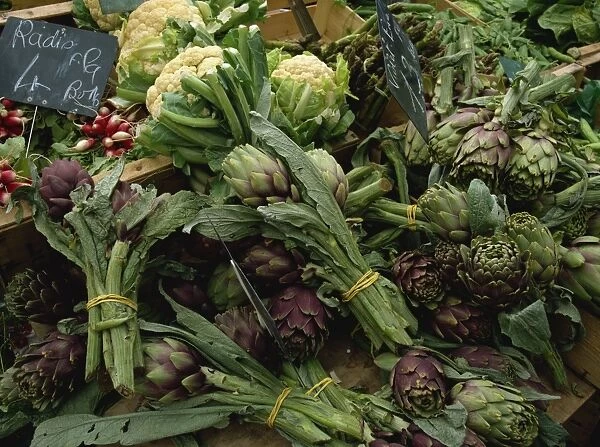 A display of vegetables, mainly artichokes and cauliflowers on a market stall in Normandy