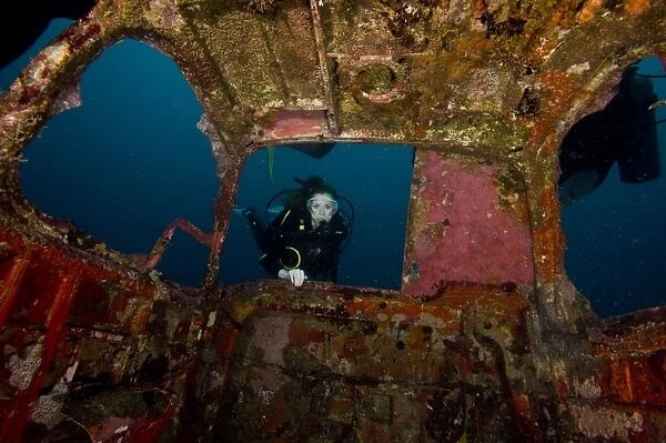 Diver entering the front window of a four seater plane wreck, Philippines, Southeast Asia, Asia