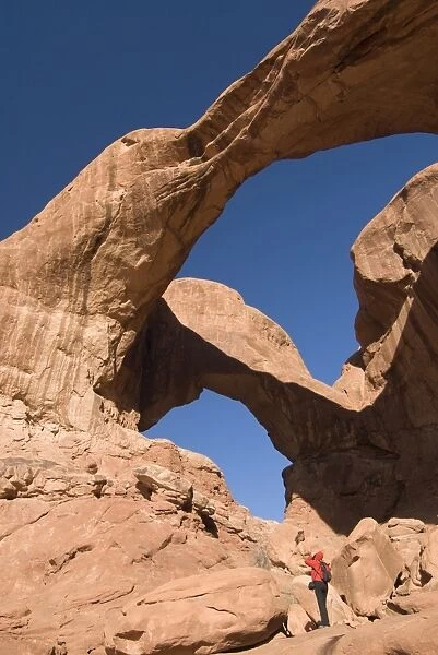 Double Arch and tourist taking a photograph, Arches National Park, Utah