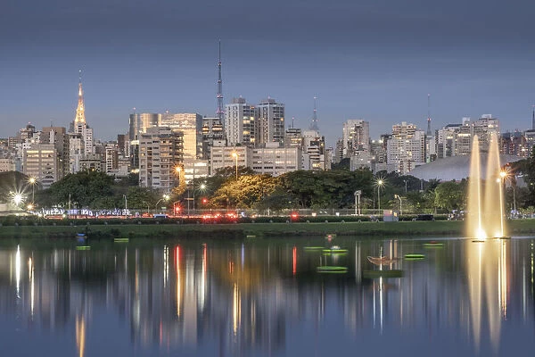 The downtown urban skyline reflected in Lago das Garcas lake at twilight, Ibirapuera Park, Sao Paulo, Brazil, South America