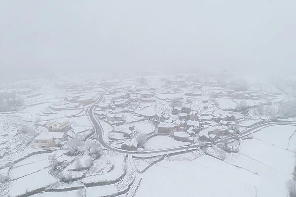 Drone aerial view of a road and remote village covered with snow in Vila Real, Norte