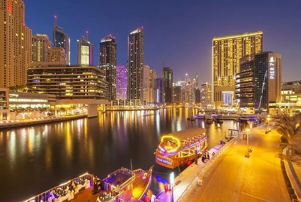 Dubai Marina skyline and tourist boats at night, Dubai City, United Arab Emirates