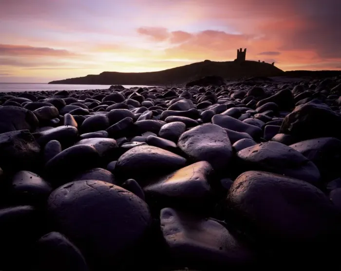 Framed Print : Dunstanburgh Castle at sunrise from Boulderfield at Embleton Bay, Northumberland Framed Print : Dunstanburgh Castle at sunrise from Boulderfield at Embleton Bay, Northumberland