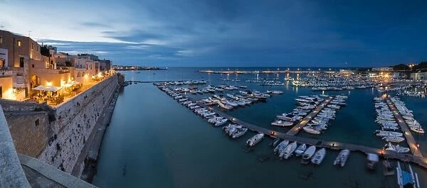Dusk lights the harbor and the medieval old town of Otranto, Province of Lecce, Apulia