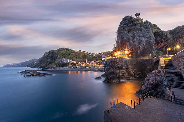 Dusk lights over the seaside town resort of Ponta do Sol washed by the ocean