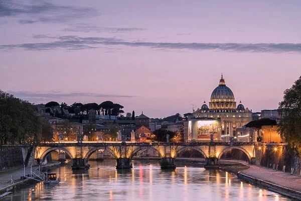 Dusk lights on Tiber River with bridge Umberto I and Basilica di San Pietro in the background