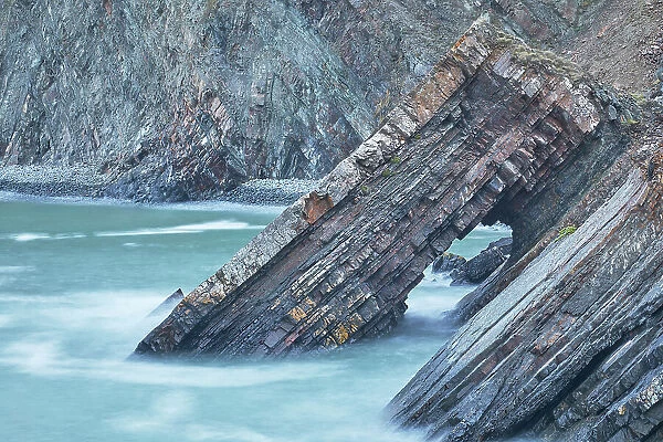A dusk view of a rock arch formed from layers of sedimentary rocks, at Hartland Quay, on the Atlantic coast of Devon, England, United Kingdom, Europe